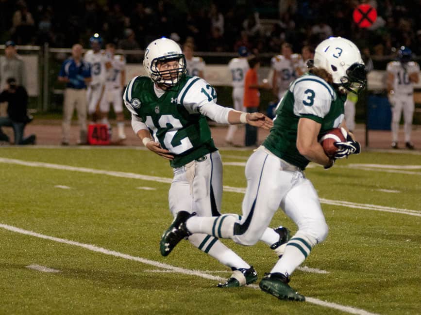 Trent Peterson hands the ball off to running back Ben Coakwell.